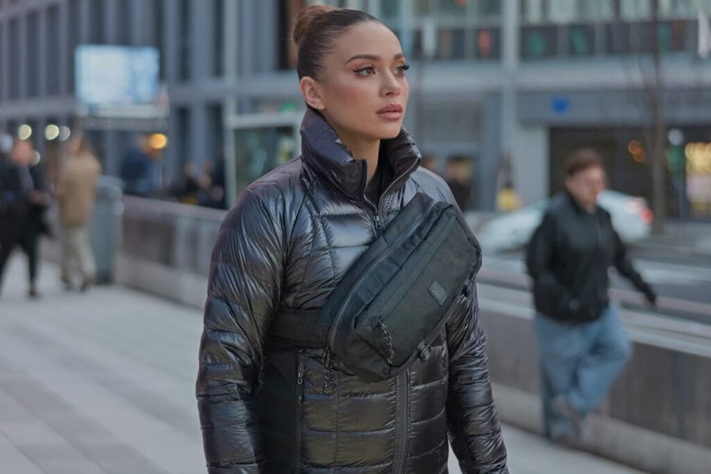 Best Sling Bag Chrome Industries Mini Kadet urban street scene with stylish puffer jacket and skyscrapers.
