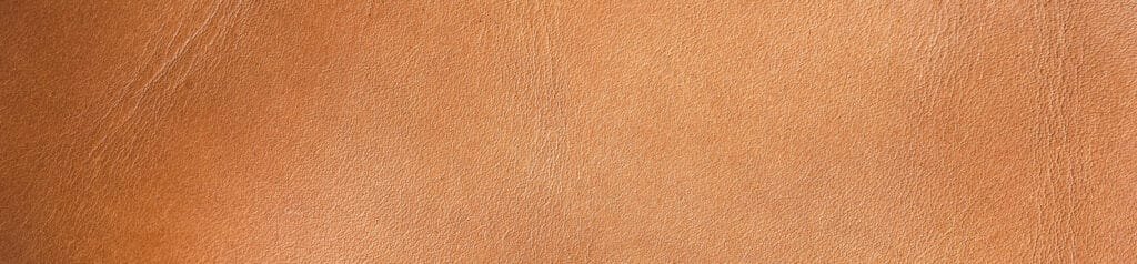 Best sling bag leather close-up highlighting warm tan texture and fine natural creases.