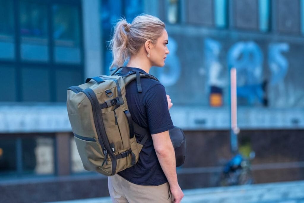 Best Travel Backpack Aer Travel Pack 3 in urban setting showcasing functionality and style with cityscape.
