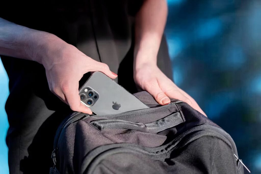 Best Travel Backpack Aer Travel Pack 3 outdoors with smartphone insertion highlighting sleek design.