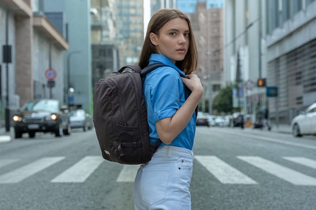 Best travel backpack review showcasing Heimplanet Travel Pack 28L V2 on a bustling city street.