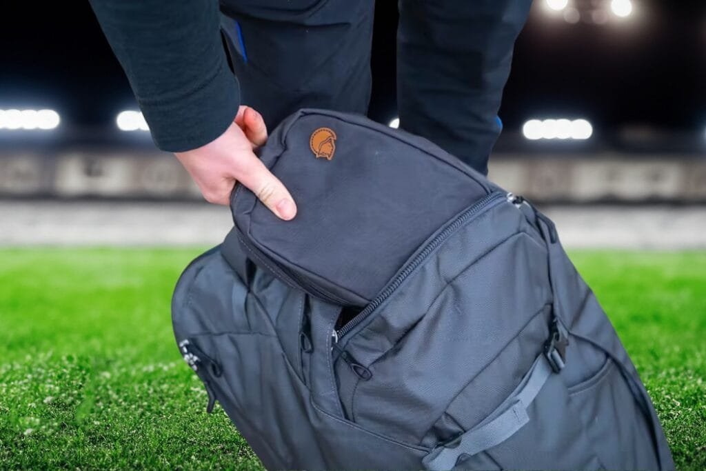 Osprey Farpoint 40 backpack user organizing gear in outdoor setting, emphasizing functionality and preparation.