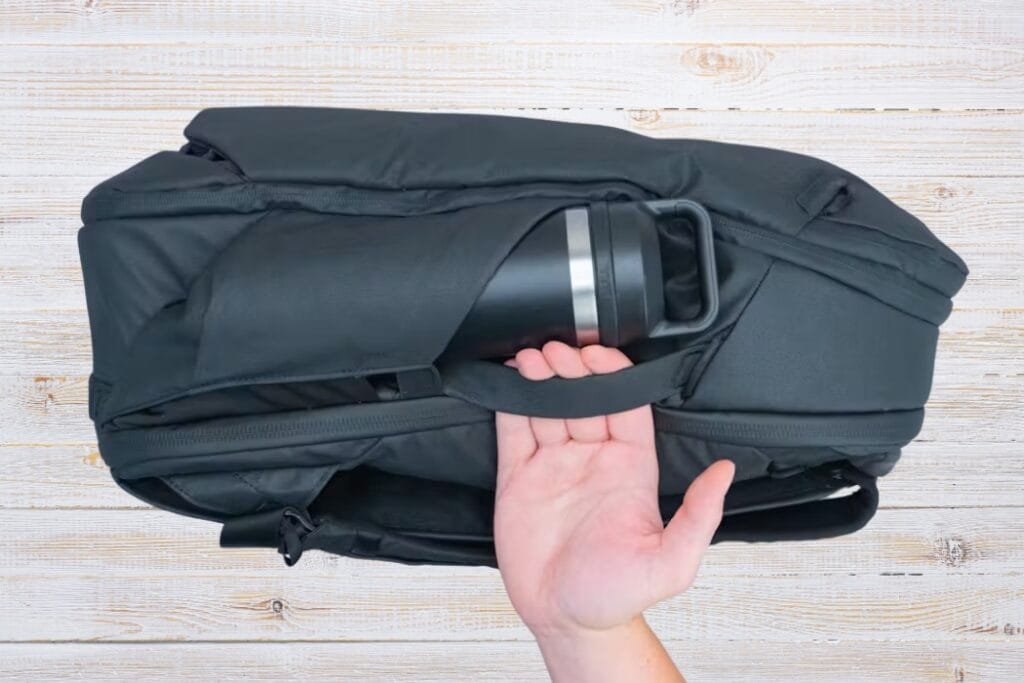 Peak Design Travel Backpack 30L with padded handle, sleek design, and integrated side pocket holding a thermos.