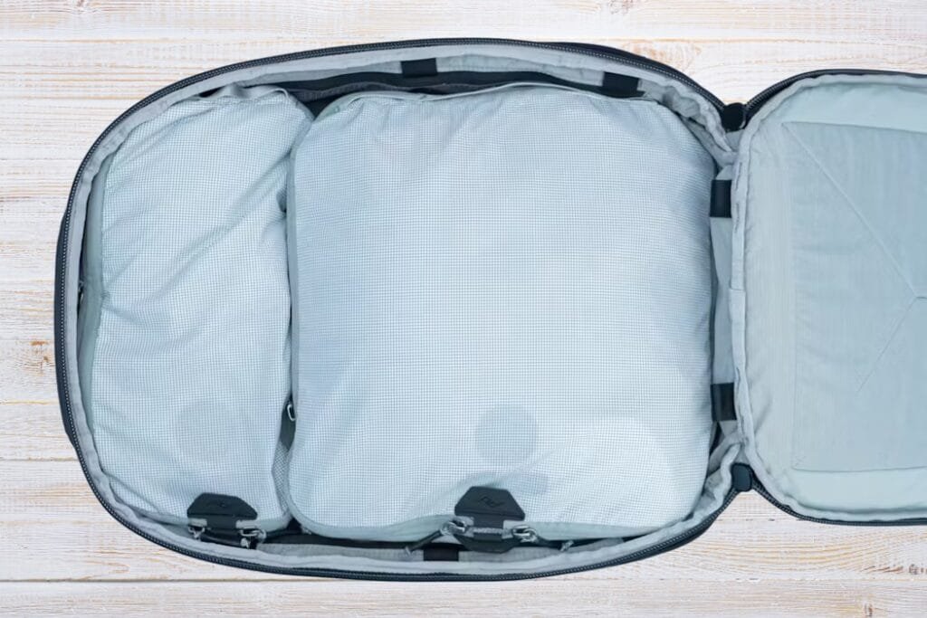 Peak Design Travel Backpack 30L interior view with organized packing cubes and compression straps on light surface.